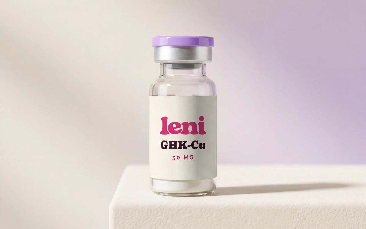 A Leni GHK-Cu vial on a cream plinth against a cream and lilac backdrop.